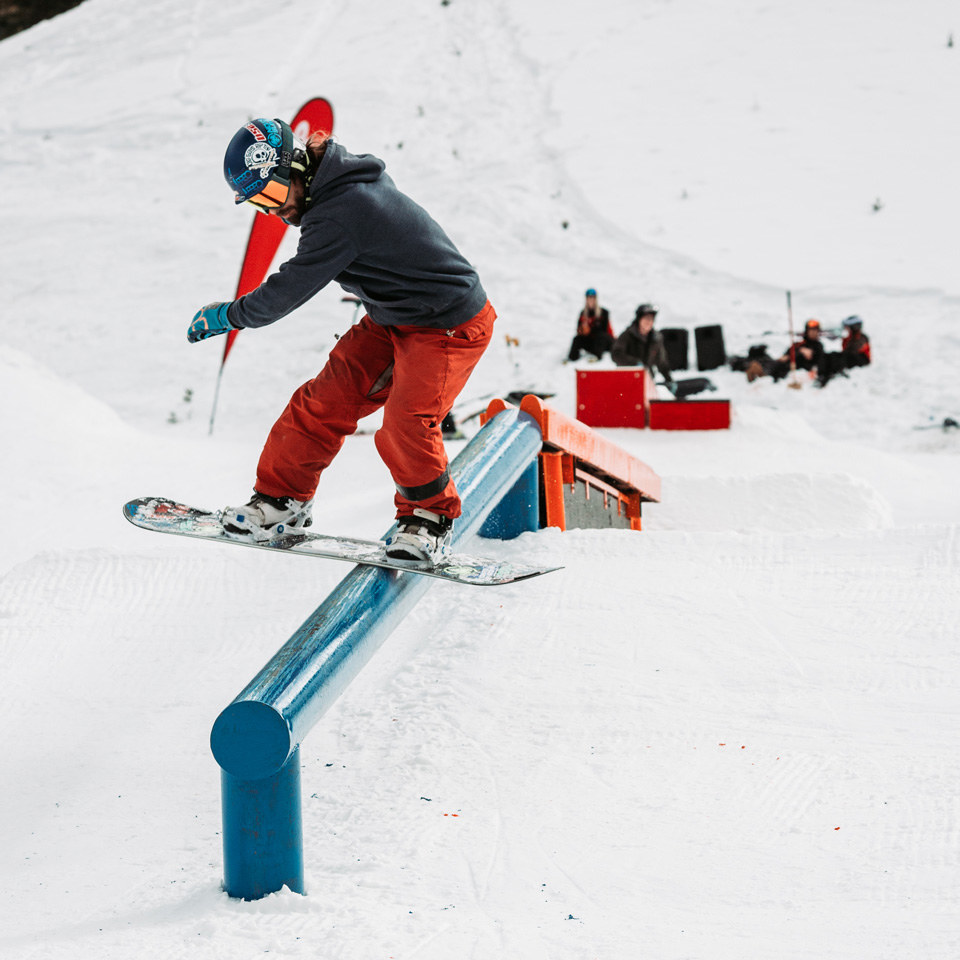 snowboarder hitting a rail in the terrain park